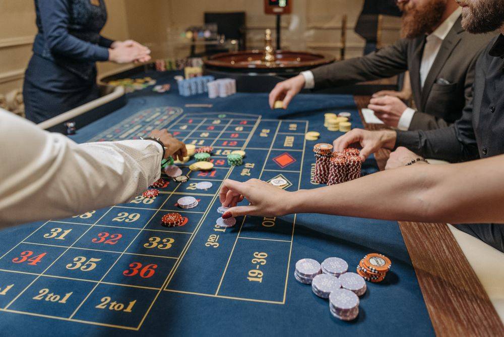 Tangan pemain menempatkan chip pada meja taruhan roulette