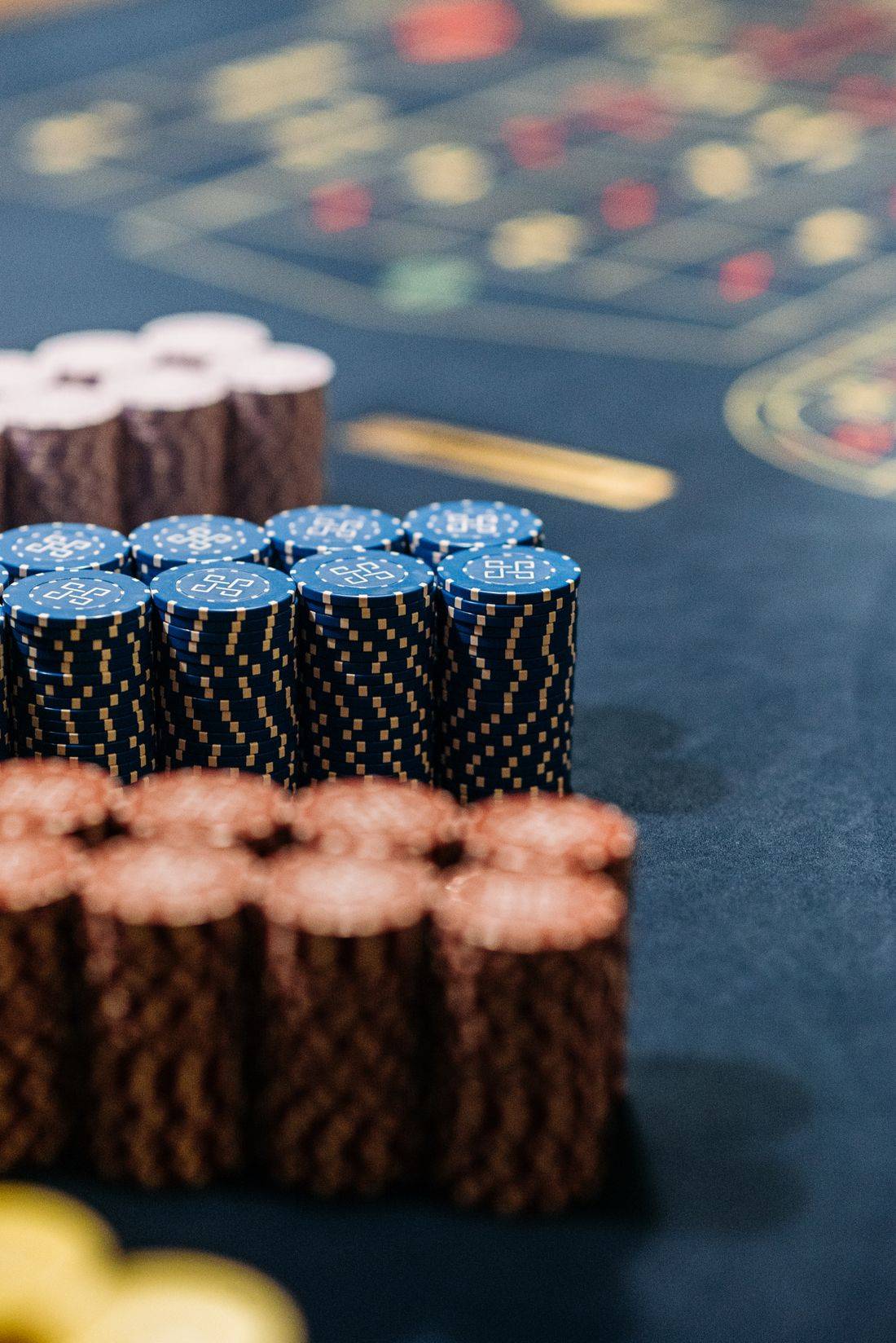 Meja roulette kasino dengan tumpukan chip warna-warni