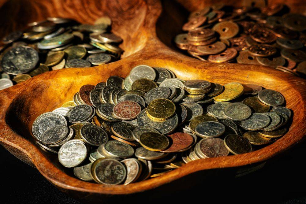 Koin rupiah tersusun dalam mangkuk kayu sebagai ilustrasi bonus selamat datang